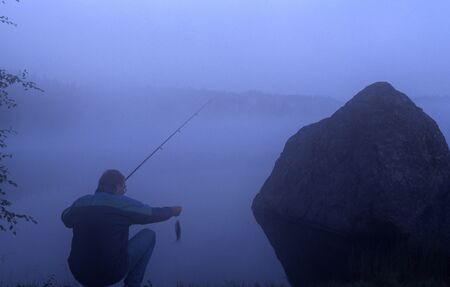 Norway, Akershus, Bærum, the lake Triungsvann, angler with perch.の写真素材