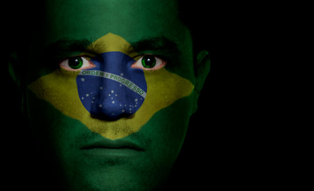 Brazilian flag painted/projected onto a man's face.の写真素材