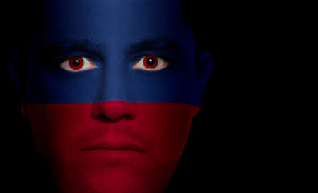 Haitian flag painted/projected onto a man's face.の写真素材