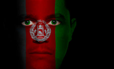Afghani flag painted/projected onto a man's face.の写真素材