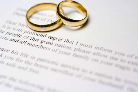 Condolence letter to wife of soldier killed in war with two wedding rings.  Shallow depth of field.の写真素材