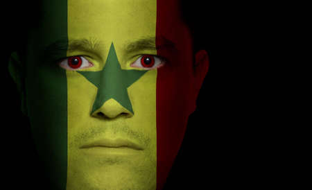 Senegalese flag painted/projected onto a man's faceの写真素材