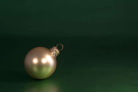 Gold Christmas ornament on green wrapping paperの写真素材