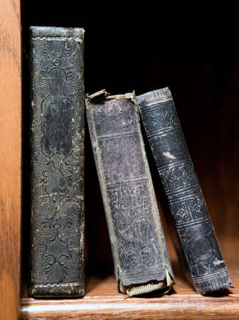 Three old books sitting on a bookshelfの写真素材