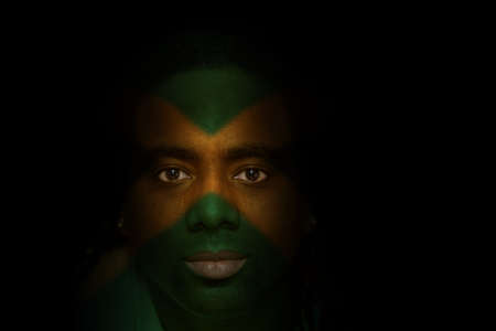 Man with Jamaican flag painted/projected onto his face.の写真素材