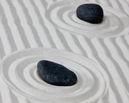 Close-up of stones on raked sand in a Japanese ornamental or zen garden.