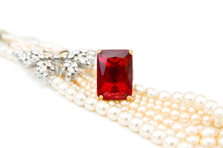 Beautiful jewellery - red ruby ring, diamonds butterfly and string of pearls. Isolated over white background.の写真素材