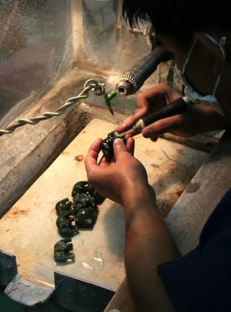 Asian man polishing a small jade elephantsの写真素材