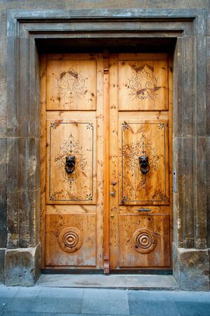 Old wooden door with lion-shaped door knockersの写真素材