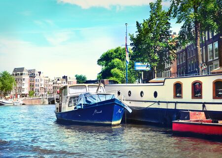 Canal at Amsterdam city, Netherlands. Boats and cityscape of Amsterdam at aa sunny day. Boats...