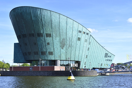 NEMO science center of Amsterdam. Maritime museum near Amsterdam Centraal Station. Futuristic building exterior at a sunny day in summer.のeditorial素材
