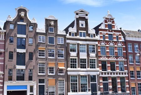 Dutch houses at a canal in Amsterdam. View to historic facades of cobblestone and stucco. Copy space.のeditorial素材