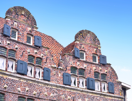 old town houses of cobblestone with clear blue sky. Antique, traditional row houses in the Netherlands.のeditorial素材