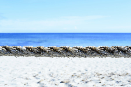 Beach barrier. Beach area, segmented with rope. Turquoise beach with blue sky and white sand in...