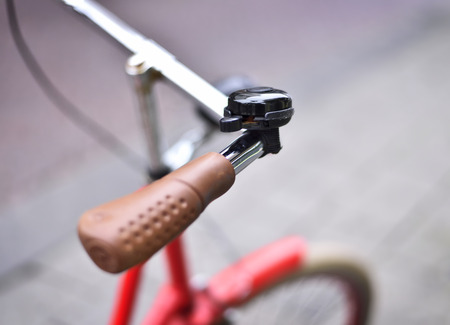 Red vintage bicycle with selective focus on the handlebar and bicycle bell. Macro shot with copyspace.の写真素材