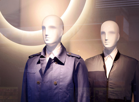 Male plastic mannequins behind a fashion store window. Two white display dummies. View through a shop window.の写真素材
