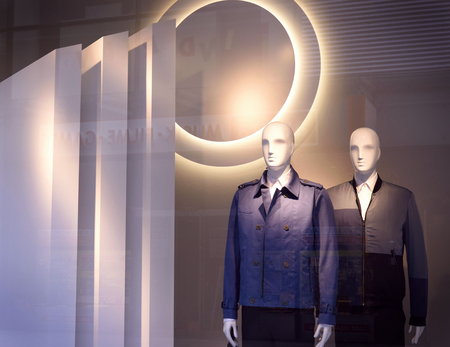 Male plastic mannequins behind a fashion store window. Two white display dummies. View through a shop window.の写真素材