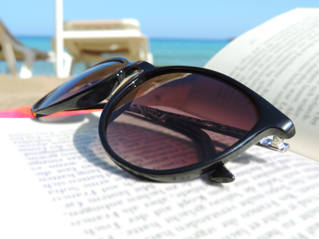 Sunglasses and book on the beachの写真素材