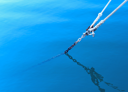 Anchored boat, rope in thew waterの写真素材