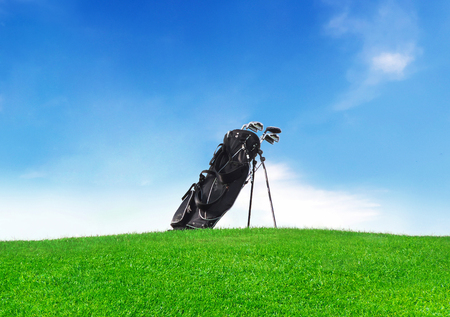Golf bag on a green meadow with clear blue sky and copyspace.の写真素材