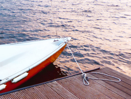Little sailboat, anchored at a wooden pier.の写真素材