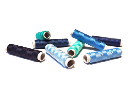 Sewing bobbins of blue color, isolated on white background.