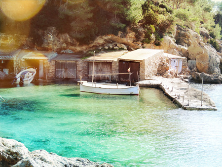 Fisherboat in the sun with lens flare and pastel colored water ..の写真素材