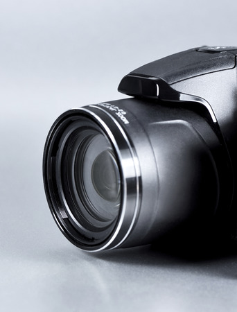 Digital camera, close-up shot on gray background.の写真素材