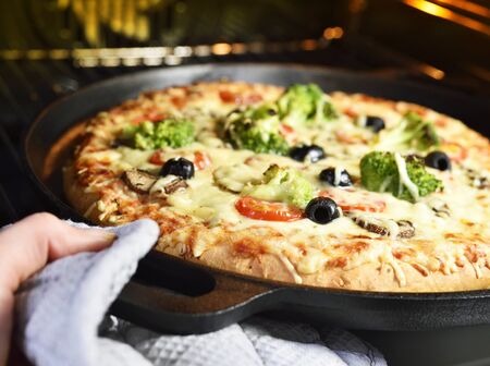 delicious vegetarian pizza, handmade pizza in a pizza pan. Oven scene.の写真素材