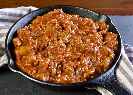 Bolognese sauce with parmesan cheese in a pan or iron pan. Italian cuisine background with pasta and slate plate.の写真素材