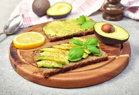 Delicious fresh avocado meal on a wooden cutting board. Healthy eating or lifestyle theme with...