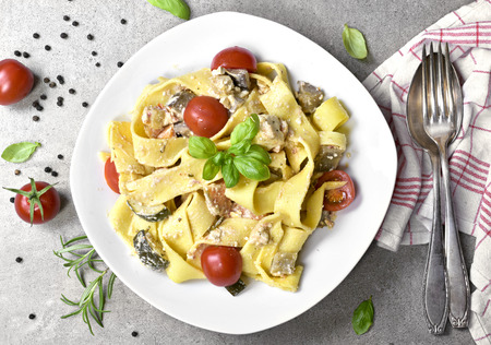 Delicious pasta dish with ricotta and fresh herbs. Tagliatelle noodles on a white plate, italian cuisine. Top view or high angle shot.の写真素材