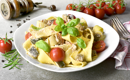 Delicious pasta dish with ricotta and fresh herbs. Tagliatelle noodles on a white plate, italian cuisine. Top view or high angle shot.の写真素材