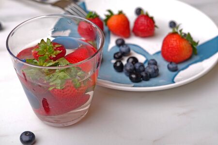 Strawberry and blueberry dessert soaked on waterの写真素材