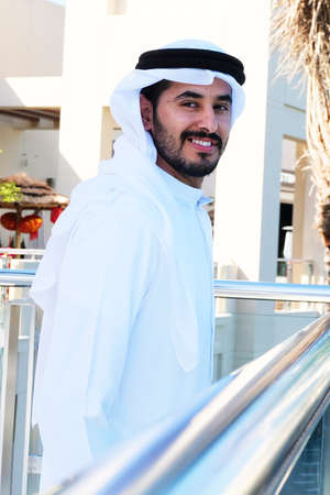 Handsome Arabic guy looking happy and smiling wearing kandoora dishdasha