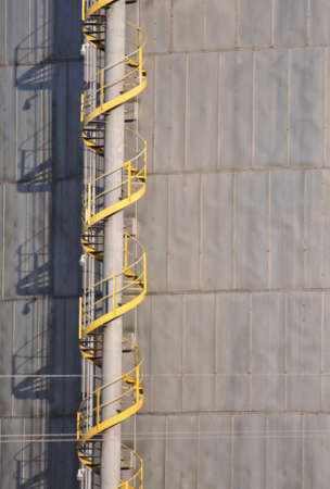 Yellow staircase spiraling to the top of a natural gas holding facilityの写真素材