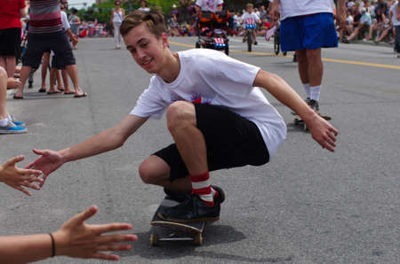 COEUR D ALENE, IDAHO 6-4-2014  4th of July Parade in downtown Coeur d  Alene; young man high slaps...
