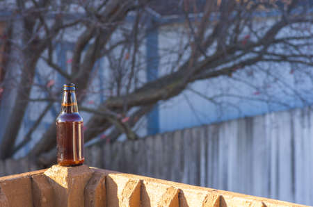 Bottle of beer on rail with tree in background 2の写真素材