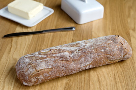 Crispy ciabatta, butter on white butter dish . Fresh bread, fried crust . Italian food. Wooden...