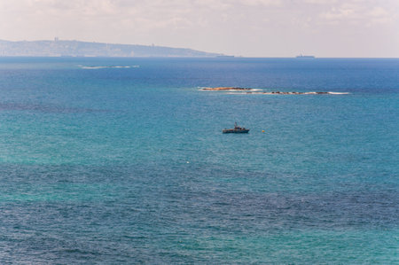 Rosh Hanikra, Israel - May 20, 2012: View on patrolling Israeli army sea ship in Mediterranean Sea bay with Haifa cityscape on the backgroundのeditorial素材