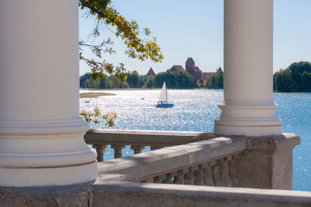 Trakai, Lithuania - October 23, 2013: Seascape composition view through the white columns on floating classic yacht around the medieval Trakai castleのeditorial素材