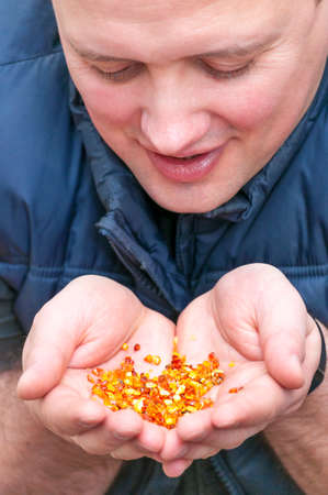 Portrait of young happy Caucasian Ethnicity man showing fistful of amber stones in his hands on...