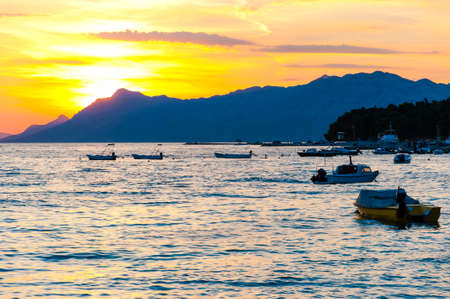 Sunset motorboats on the Adriatic sea beach in Makarska, Croatiaの写真素材