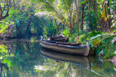 Traditional boat of Kerala Backwaters moored to the shore. Backwaters in Kerala is a network of 1500...