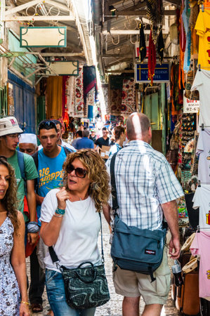 Jerusalem, Israel - May 25, 2012: Walking people in ancient Old Town Market of Jerusalem full of shops with all kinds of touristic products like t-shirts, souvenirs, bags, textile and moreのeditorial素材