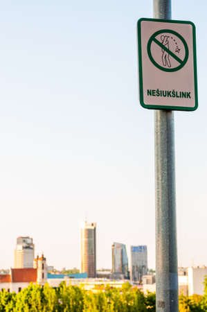 Vilnius, Lithuania: The social issues information sign on lantern column that asking do not litter nowhere in the city with cityscape view on the backgroundの写真素材