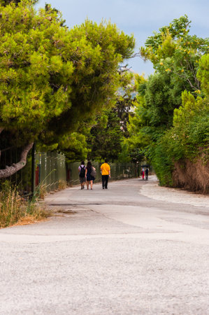 Athens, Greece - June 12, 2013: People going down from Acropolis hill by cozy walkway between...