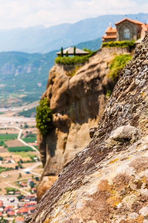 Meteora, Greece - June 16, 2013: Panoramic view on scenic Meteora landscape rock formations with Saint Stephen Nunnery Monastery on the cliff and Kalabaka town just above the mountainのeditorial素材