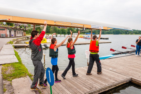 Trakai, Lithuania - July 26, 2013: Tourists carrying an eight that is a rowing boat used in the...