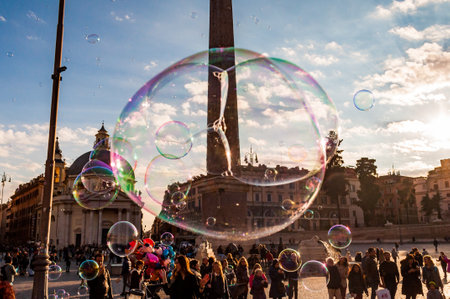 Rome, Italy - November 18, 2018: Soap bubbles flying on Piazza del Popolo, People Square in Rome full of happy positive people, tourists and locals with Roman architecture on backgroundのeditorial素材